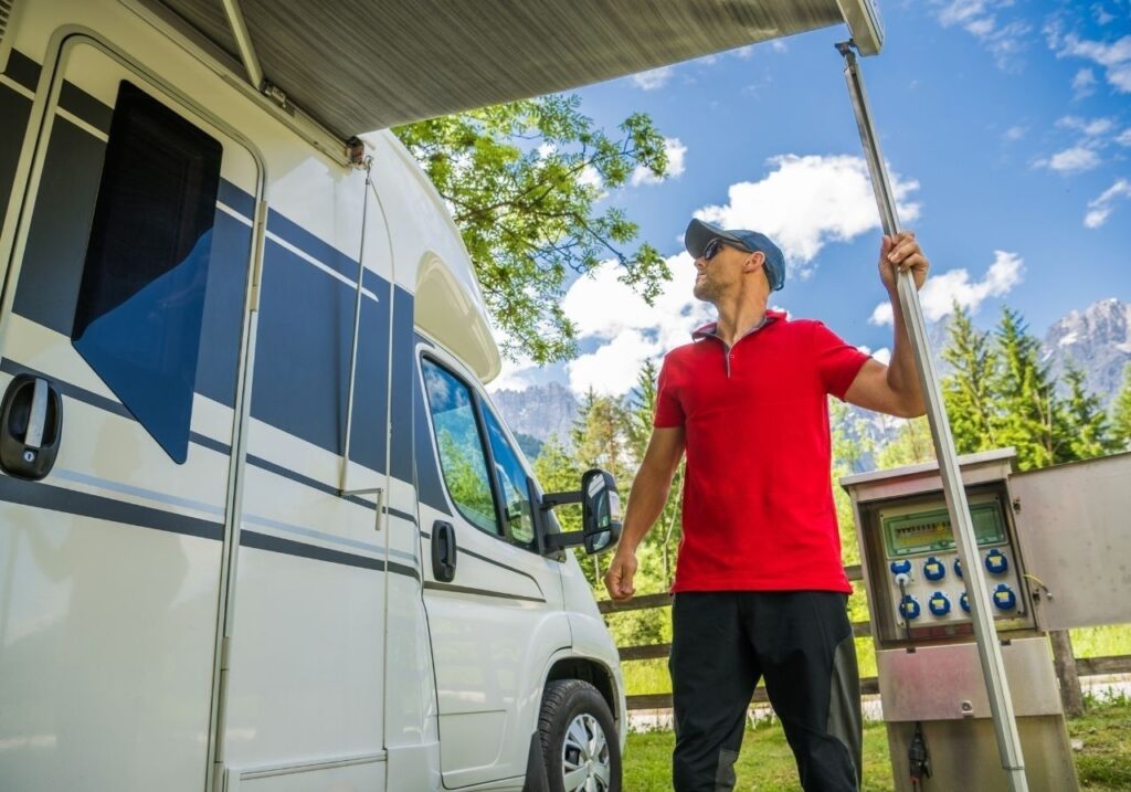 Smiling RV tech standing beside service van with Las Vegas Mobile RV Repair branding