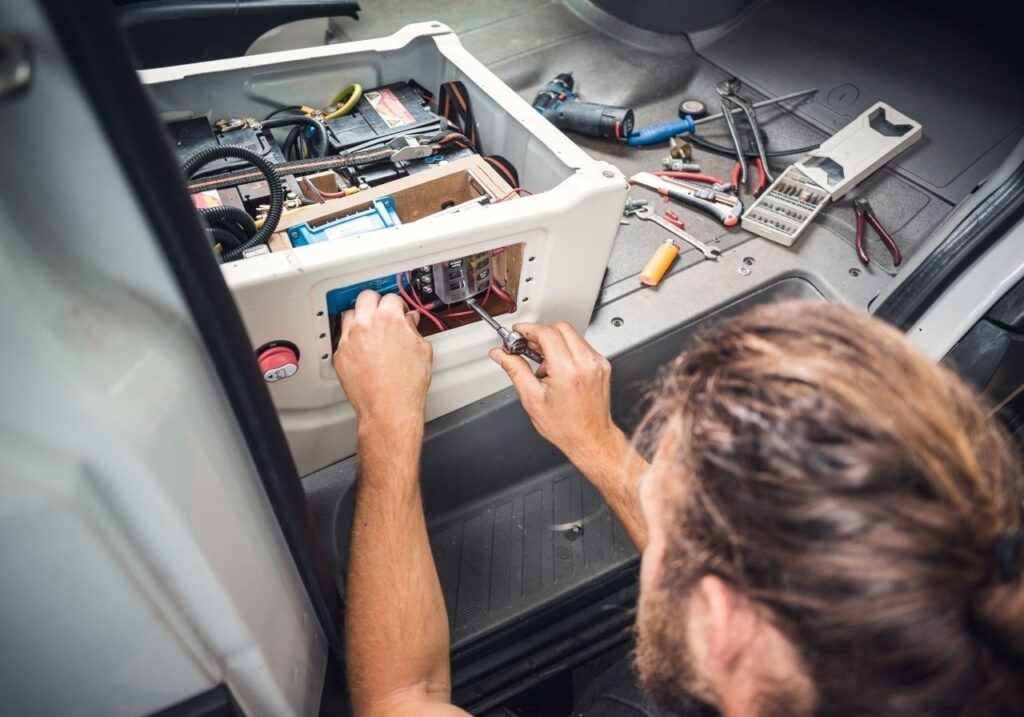 Close-up of RV fuse box with technician testing electrical system