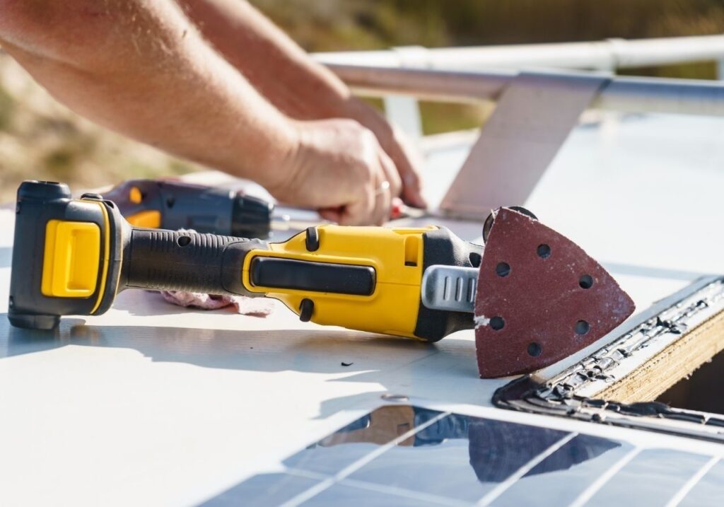Close-up of cracked RV roof sealant being resealed during mobile repair service